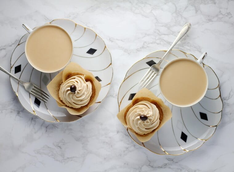 Two cups of tea with cupcakes
