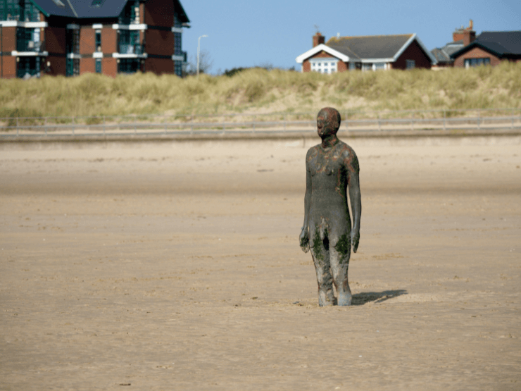 A statue of a man standing up at Crosby Beach