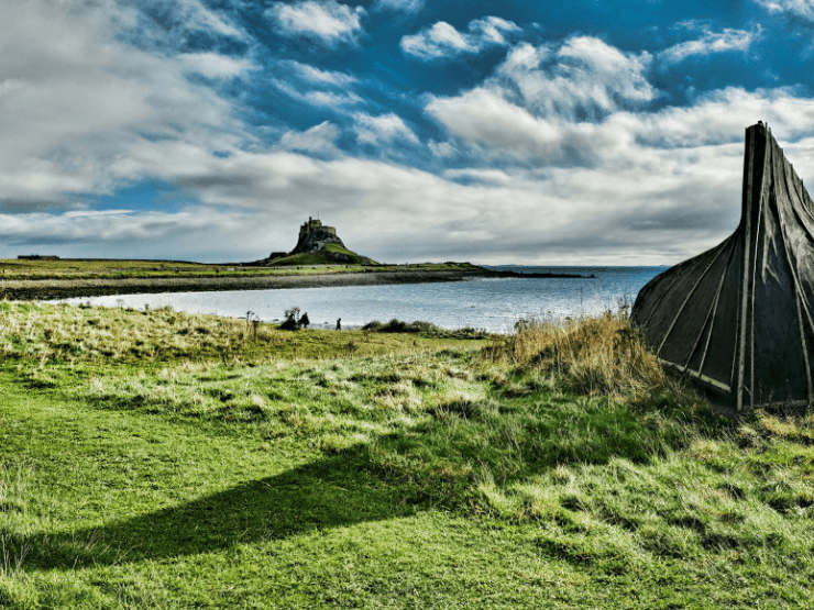 Green grass at Holy Island with a castle ruin and the ocean visible