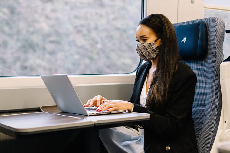 Woman wearing mask on a laptop on a TransPennine Express train