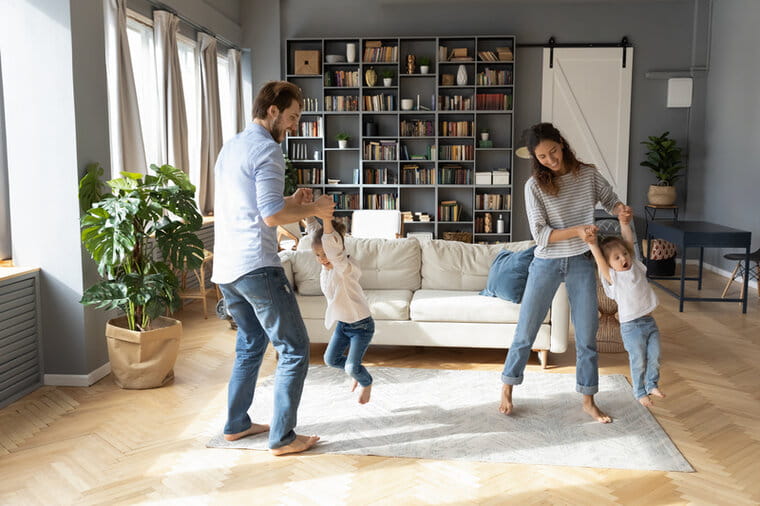 Man and woman dancing with two children in the living room