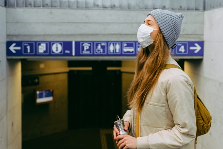 Woman in mask at train station