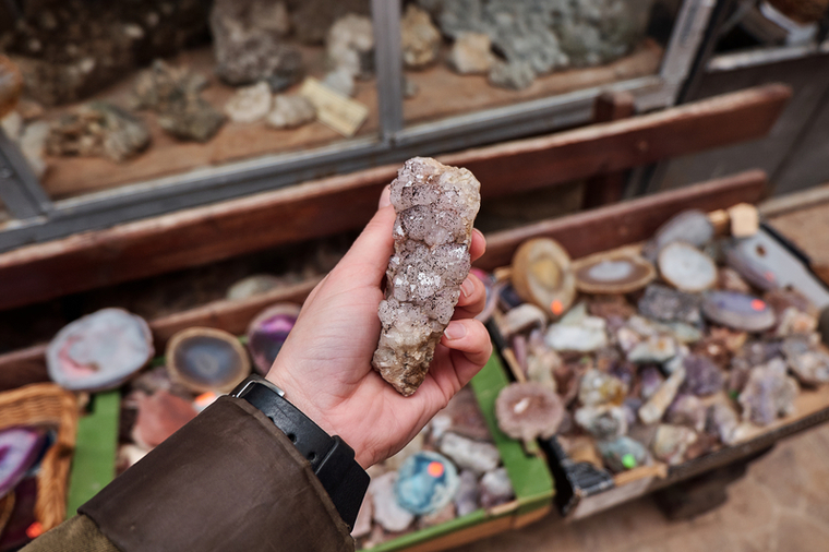 Person holding a crystal at a shop