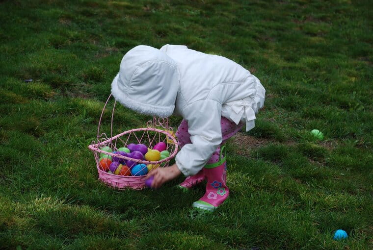 Child collecting easter eggs in garden